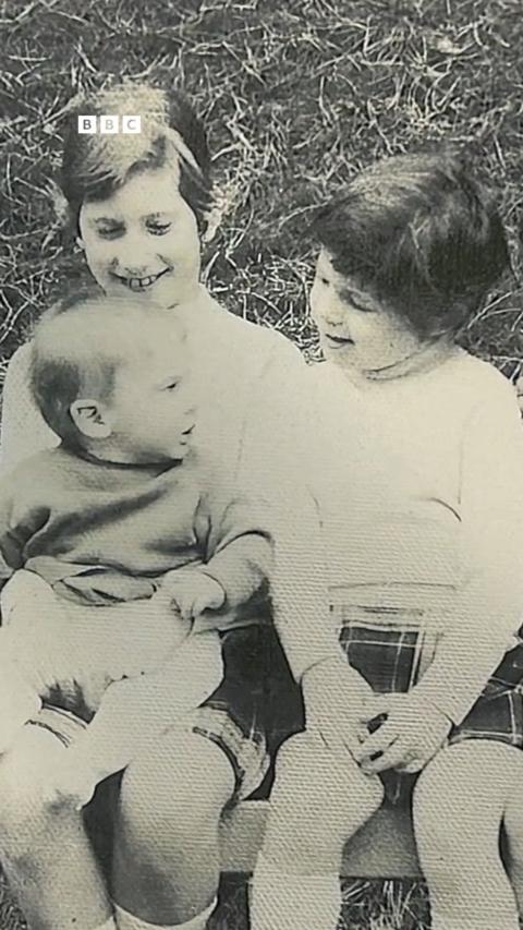 Three children in a black and white photo.