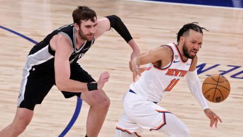 The San Antonio Spurs' Luke Kornet chases the New York Knicks' Jalen Brunson