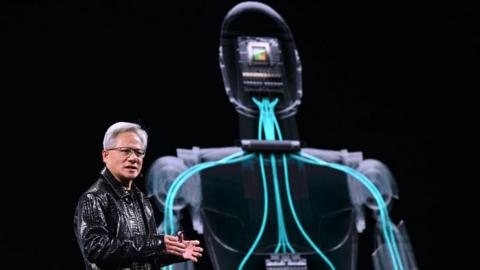 Jensen Huang's making his keynote address at CES, an annual technology show in Las Vegas. He is standing in front of a projection of a robot.