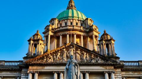 Belfast City Hall from below against a blue sky