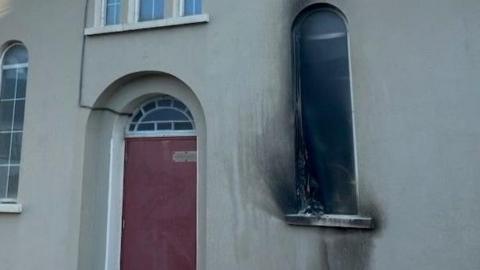 Shows scorch damage to a window and a red door 