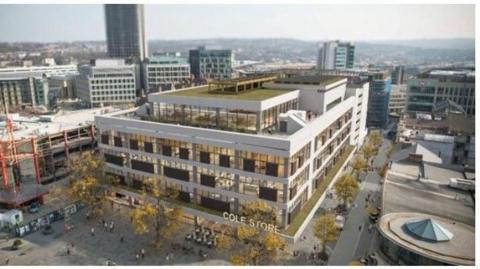An artist's impression shows an updated picture of the old John Lewis building from the sky. It has brown tiling, windows and a white facade and overlooks Barker's Pool with trees