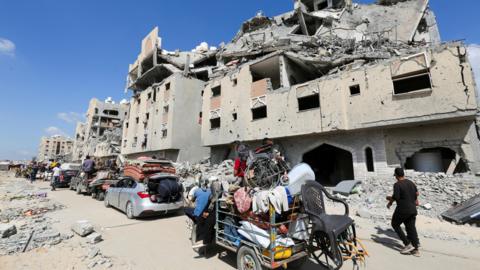 Displaced Palestinians make their way as they flee following an Israeli evacuation order in Khan Younis