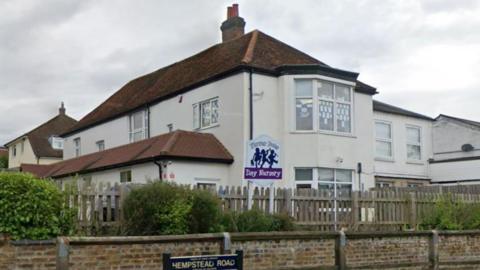 A building that looks similar to a two storey house has a sign outside for Flower Pots Nursery