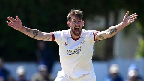 Playing in a Championship game, Tom Bailey has both arms outstretched appealing for a wicket towards the umpire