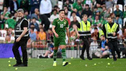 Jamie McGrath walks between tennis balls during the protest