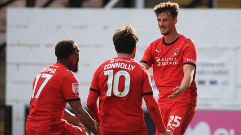 Leyton Orient players celebrate with match-winner Charlie Wellens