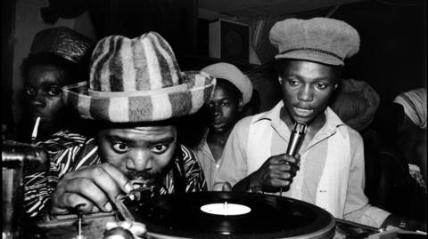 Two men performing music with a vinyl