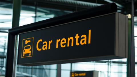 Sign with direction to car rental