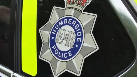 A close up of a Humberside Police car showing the force badge in the window