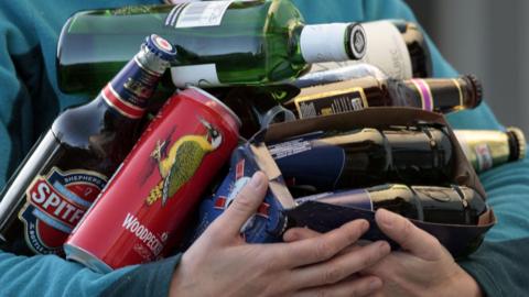 Person carrying bottles and cans of beer