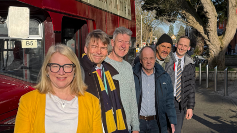 Sophie Law, Ian Loader, David Henwood, Graham O'Donnell and Lucke Marrion stood next to a vintage red bus.