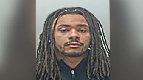 Andrew Phillips is staring directly at the camera and he has no expression on his face in his police mugshot. 