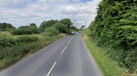 Rural tree-lined 40mph road in Worton, Wiltshire
