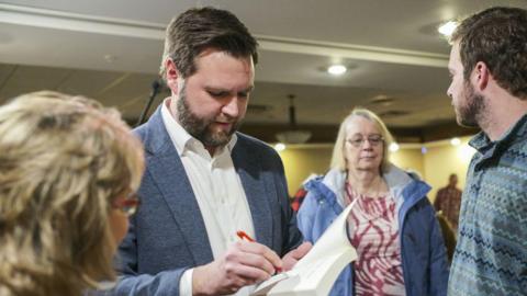 Ohio Sen. JD Vance signs a copy of his book 