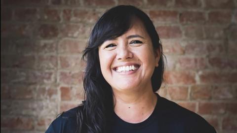 A smiling woman with long black hair.