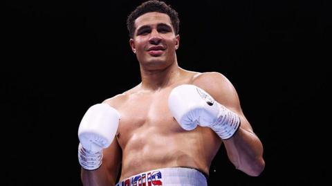 Delicious Orie poses with his white boxing gloves in the ring