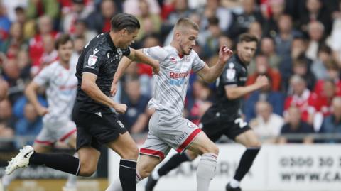 Crawley Town's Ronan Darcy (10) goes past Wrexham's George Dobson (15)