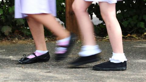 A blurred image of two young school girls running.