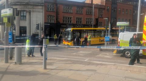 A tram stop is pictured with police cordon tape blocking the route