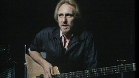 John Entwistle of the Who holds a bass guitar