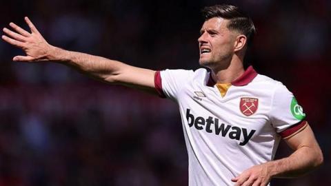 Aaron Cresswell holds out his right arm as he instructs team-mates during a game for West Ham
