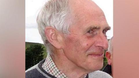 A man with grey hair seen from the side