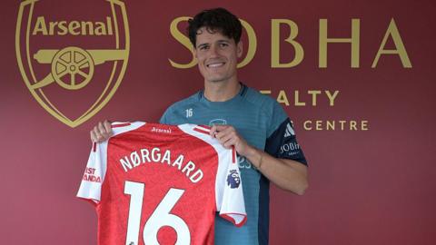Christian Norgaard holds an Arsenal shirt