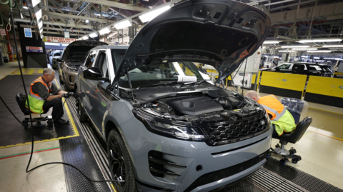 Staff members assemble Range Rover Evoque SUVs on the production line at Jaguar Land Rover's Halewood factory in Liverpool