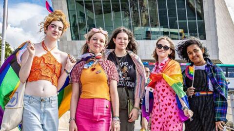People wearing bright clothes and enjoying Liverpool in Pride on Liverpool Waterfront.