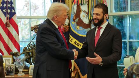 Donald Trump, left, wears a navy suit and red tie and is seen shaking hands with Syria's President Ahmad al-Sharaa.