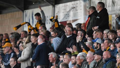 A picture of Annan fans waving scarves in the air at Galabank