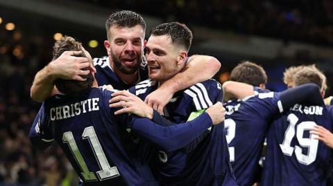 Scotland players celebrate with Grant Handley in the middle
