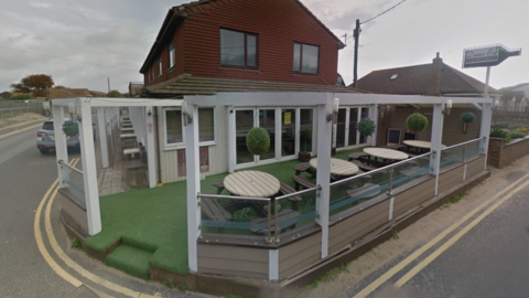 Dunes Bar and Restaurant. A brown building with white terrace.