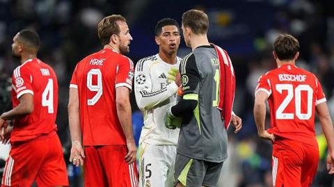 Harry Kane and Manuel Neuer speak to Jude Bellingham.