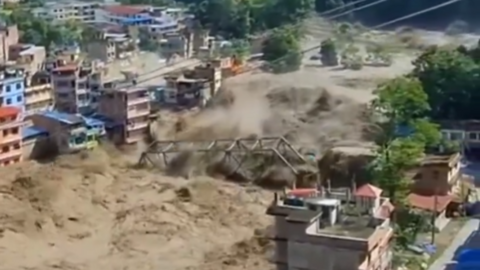 Bridge being ripped away by floodwater