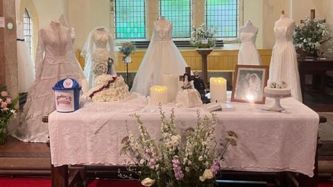 Dresses on mannequins behind a church altar