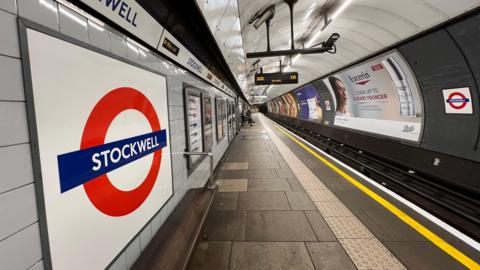 Red and white Tube roundel on empty platform at Stockwell station