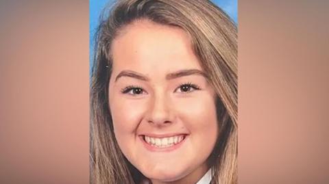 Emily Moore smiles at the camera in a school picture. She has brown eyes and long light brown hair.