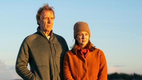 Tony Evans (Rhys Ifans), Emma Dretzin (Laura Linney)