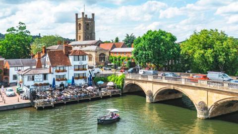 Aerial view of town centre Henley-On-Thames on Thames, Oxfordshire, UK. There is a large church in the background, whilst a stone bridge crosses the River Thames.