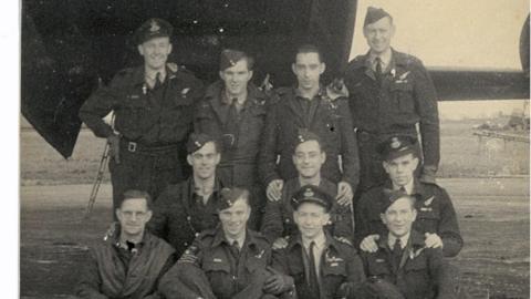 A photograph from World War Two shows the crew of a Lancaster bomber in front of their aircraft. They are in uniform, and arranged in three rows, the back row of four standing, the middle row of three kneeling, and the front row of four sitting cross-legged. James Keith Spedding is on the right-hand side end of the front row. 