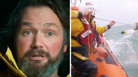 RNLI lifeguard next to orange lifeboat with a crew rescuing someone in a kayak in the sea