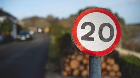 The image shows a Uk 20 miles per hour road sign.