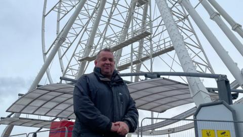 Asa Morrison, stood in front of the ferris wheel in Great Yarmouth