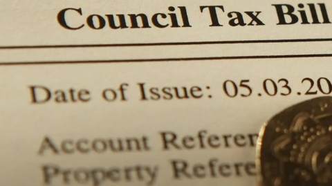 A close up of a council tax bill, with the date of issue partly cut off and account reference obscured by a 20p coin.