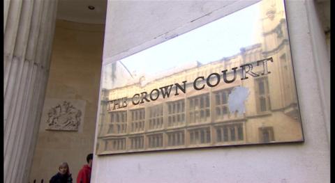 Exterior view of Bristol Crown Court, showing the entrance. There is a gold plaque on the wall saying 'The Crown Court'. 