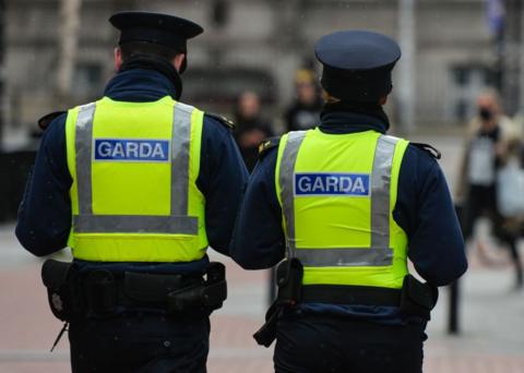 Two gardaí stand with their backs to the camera