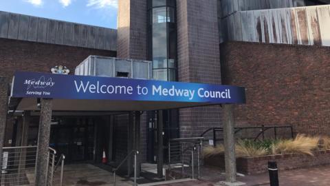 A building with a walkway covered by a blue entrance sign which reads 'Welcome to Medway Council'
