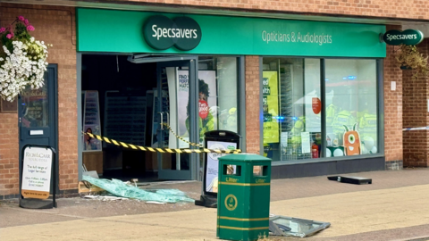 Specsavers Opticians in Blaby, Leicestershire, with damaged front entrance after a car crashed into it.